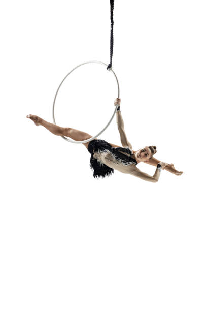 istock Young female acrobat, circus athlete isolated on white studio background. Training perfect balanced in flight 1294441598