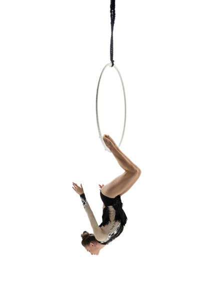 istock Young female acrobat, circus athlete isolated on white studio background. Training perfect balanced in flight 1294441614