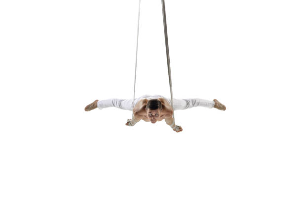 istock Young male acrobat, circus athlete isolated on white studio background. Training perfect balanced in flight 1294441628