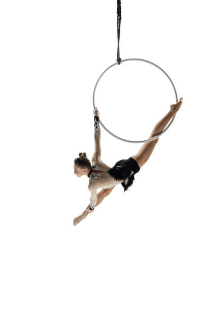 istock Young female acrobat, circus athlete isolated on white studio background. Training perfect balanced in flight 1294441677