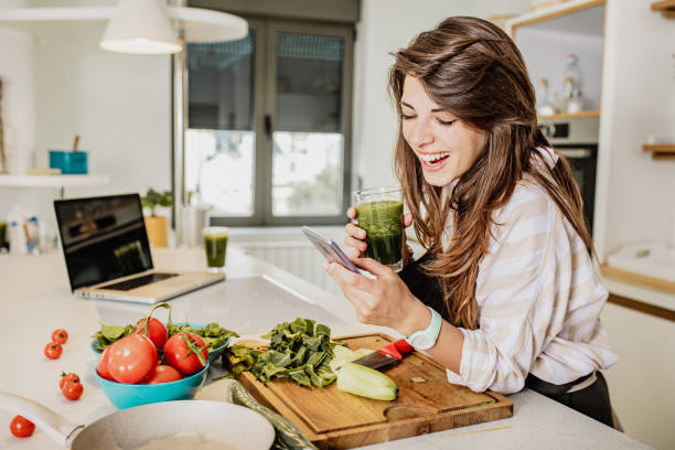 istock Young woman is in the kitchen and she is using mobile phone 1294442860