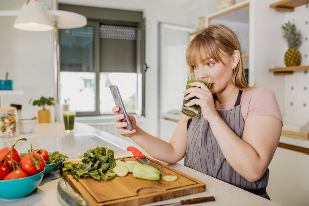 istock Young woman is in the kitchen and she is using mobile phone 1294442997