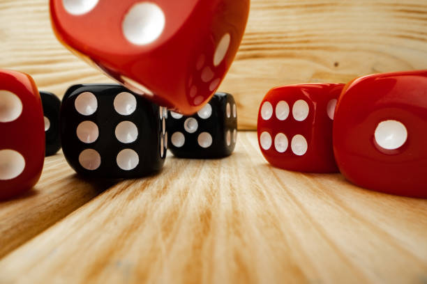 istock Red and black dice cubes on wooden background 1294443998