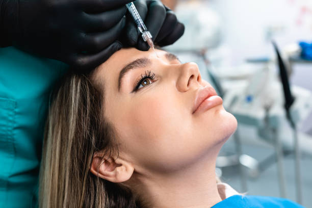 Facial aesthetics surgery treatment Attractive young woman is getting a rejuvenating facial injections at beauty clinic. The expert beautician is filling female wrinkles by botulinum. plastic surgery photos stock pictures, royalty-free photos & images