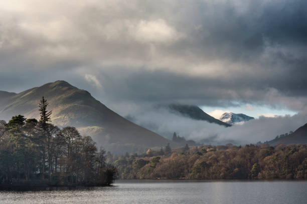 istock Dramatic landscape image looking across Derwentwater in Lake District towards Catbells snowcapped mountain with thick fog rolling through valley 1294447191
