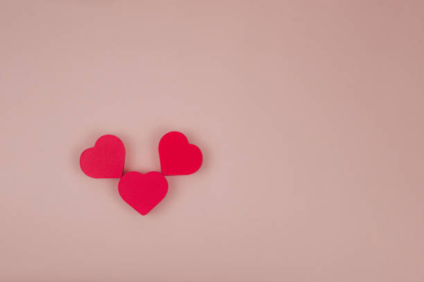 istock three red hearts on a pink background 1294450284