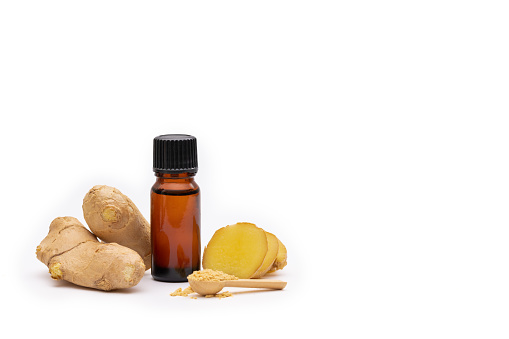 An aromatherapy oil bottle surrounded by ginger and ginger spice