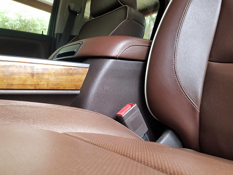 Interior of a vehicle.  Driver's side seat.  Console and seatbelt.