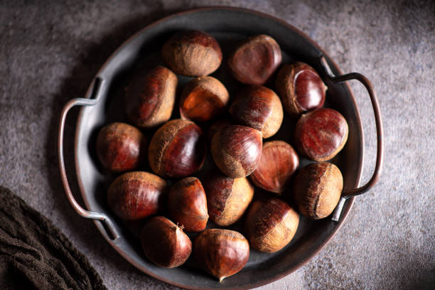istock Chestnuts on a artistic metal plate in a rustic dark setup 1294455644