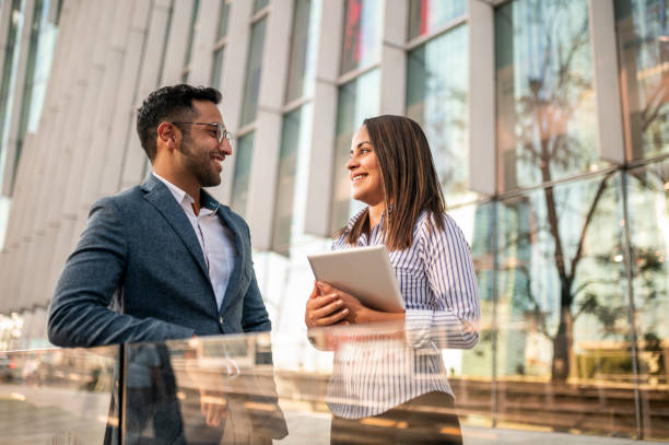 istock Two business persons standing in front of office and talking 1294457528