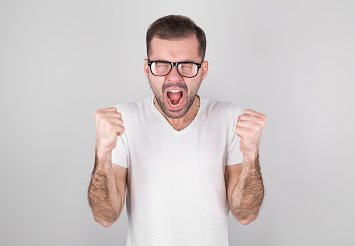 Portrait of young angry man over white background