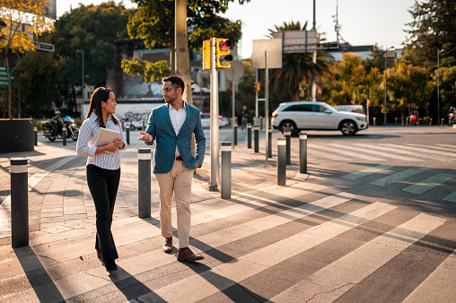 Two young people crossing the street