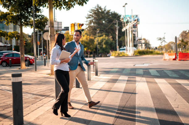 Two young business persons crossing the street Two young people walking down the street mexico street scene stock pictures, royalty-free photos & images