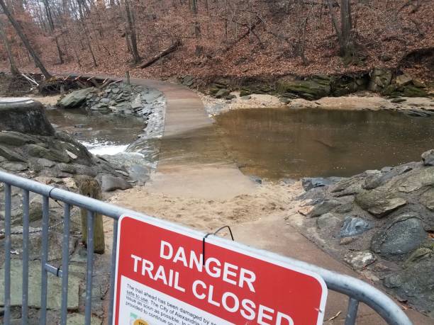 istock danger trail closed sign with path and river flood 1294461211