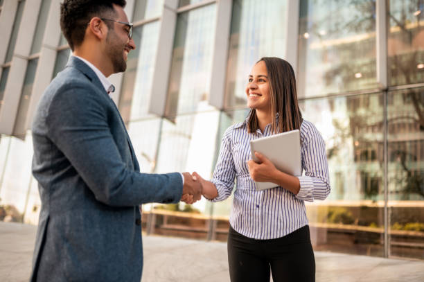 istock Two business people handshaking in front of office 1294461348