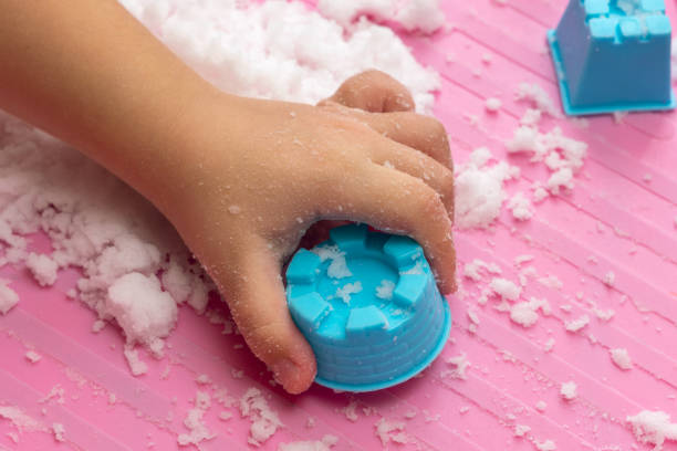 Child plays with artificial snow for home decoration.