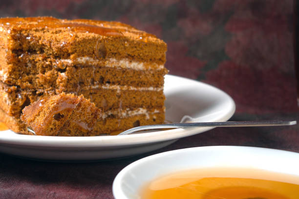 istock honey cake with honey drips lies on a white plate 1294461678