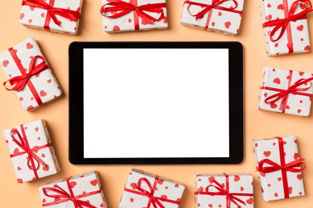 istock Top view of digital tablet surrounded with gift boxes on colorful background. Saint Valentine's day 1294463574