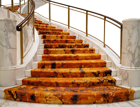 Luxurious white marble spiral staircase with modern carpet inside building. Luxurious decoration style