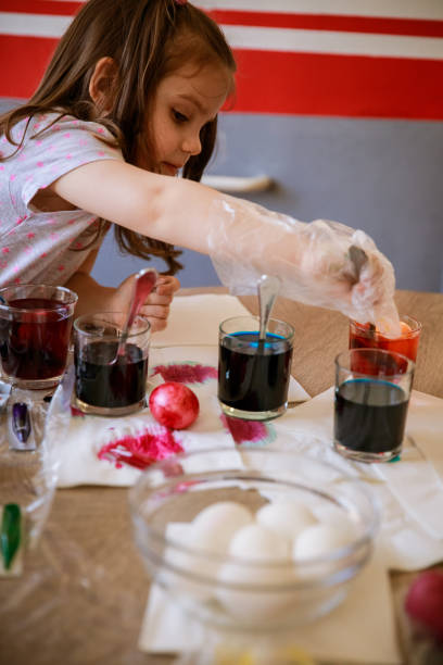 istock Little girl dying an Easter egg a yellow color 1294465010