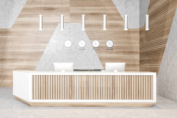 istock Reception desk in open space lobby with clocks, wooden wall and light floor 1294466458