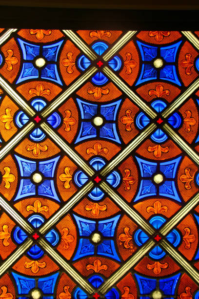 Soft light shines through an isolated stained glass window, dating to the early 1900's.
