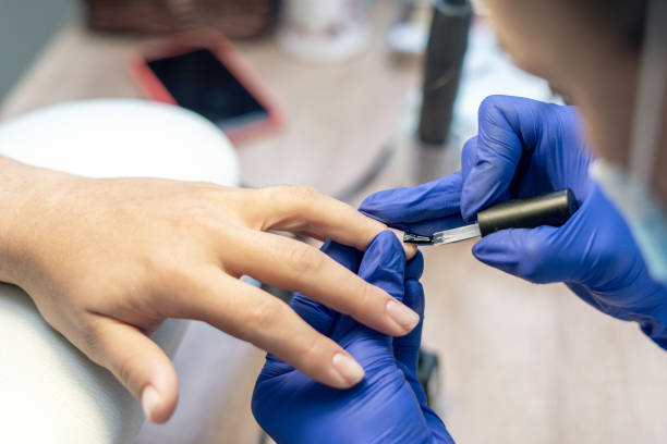 istock Manicurist doing a manicure in a nail salon, applying varnish on nails 1294467430