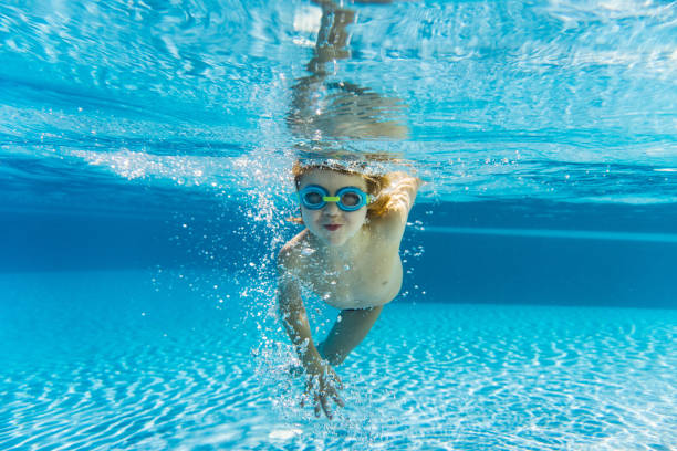 istock Smiling boy swimming under water 1294467688