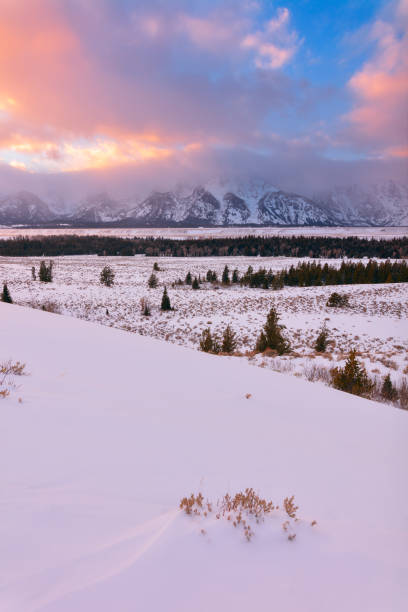 Scenic winter view of the Teton range at sunset in Grand Teton National Park, Wyoming Scenic winter landscape view of the Teton mountain range at sunset from the Snake River Overlook in Grand Teton National Park, Wyoming, USA. snake river valley grand teton national park stock pictures, royalty-free photos & images