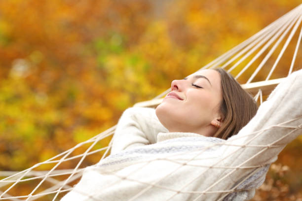 istock Relaxed woman resting on hammock in fall season 1294468584
