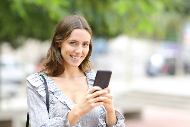 istock Happy woman holding phone looking at camera 1294468648