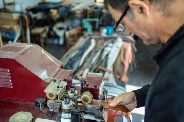 Man working at a craft production of leather goods
