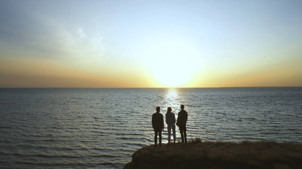 istock The three young people standing on the seascape background 1294468922