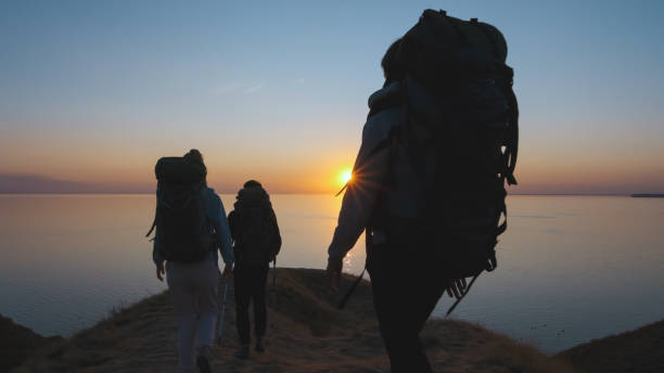 The three people hiking on the seascape background