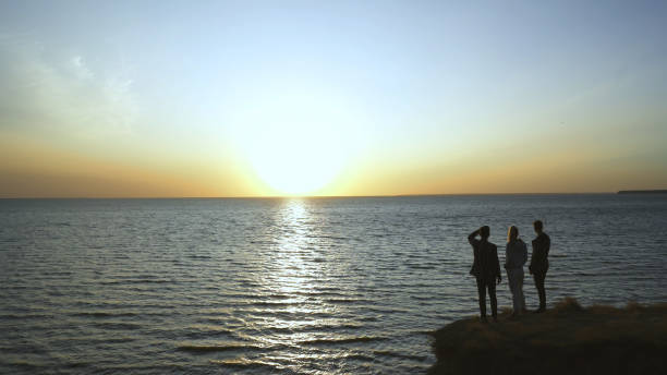 istock The three young people standing on the seascape background 1294469059