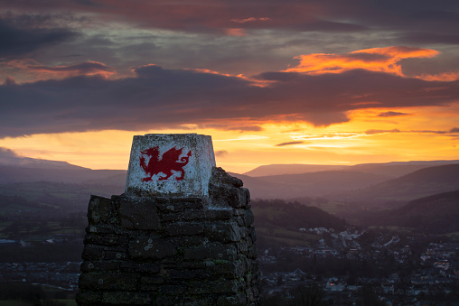 Welsh dragon monument with rolling hills and rural town backdrop - Brecon, Wales