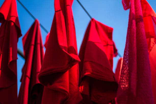 istock Vibrant Red Laundry Hung on Laundry Line, Blue Sky 1294471145