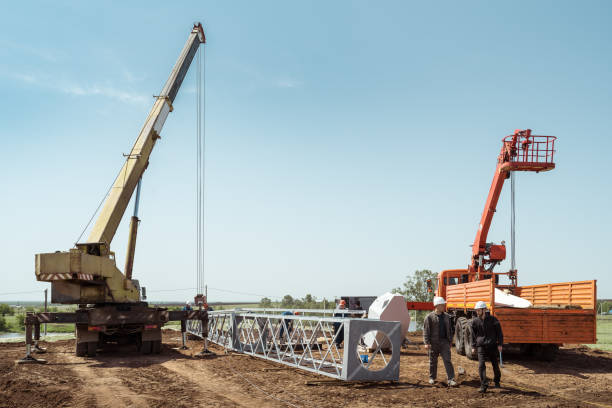 Installation of a wind turbine. Workers and engineers, truck crane and aerial platform at construction site stock photo