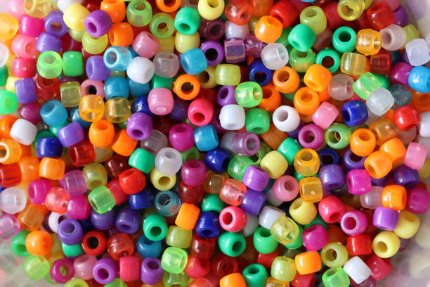 istock Multicolored plastic beads for handicraft are scattered on the table 1294473185