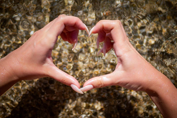 istock Female making heart shape with hands in water 1294474106