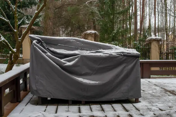 Patio furniture Cover protecting outdoor furniture from snow, close up.