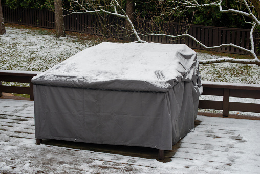 Patio furniture Cover protecting outdoor furniture from snow, close up.