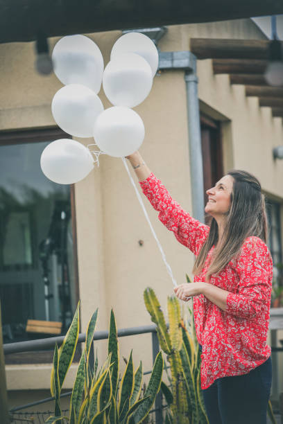 istock Beautiful woman holding white balloons 1294475344