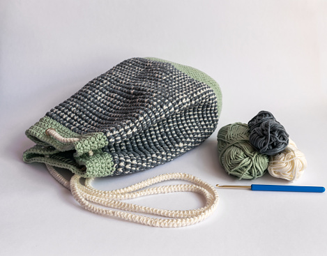 Homemade, Crocheted Mosaic stitch, Bucket Bag Backpack in Pastel Green, White and Gray color with white crocheted rope for closing. Photographed on a White background
