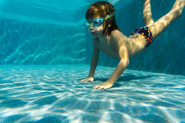 istock Happy child swimming under water 1294476989