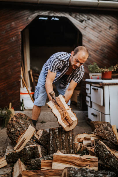 istock Young man lifting a wood stuck on his axe 1294477289