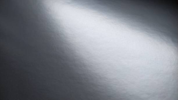 istock Gradient on a gray background. Glossy paper or foil folded horizontally with overflow and highlights. Soft corner light. A mysterious glow. Metallic silver luster. Banner 1294477615