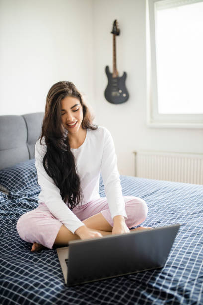 istock Young woman working from home in bed during quarantine 1294480546