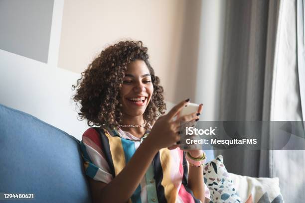 Teen Girl Using Smartphone On Sofa Stock Photo - Download Image Now - Teenager, Mobile App, Happiness
