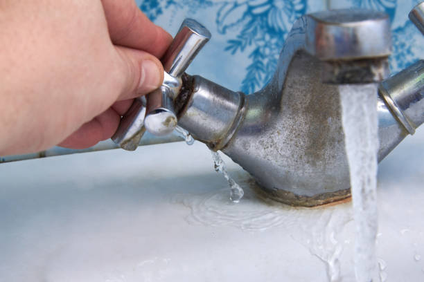 istock Water leaking from a rusty old faucet in the bathroom. 1294482019